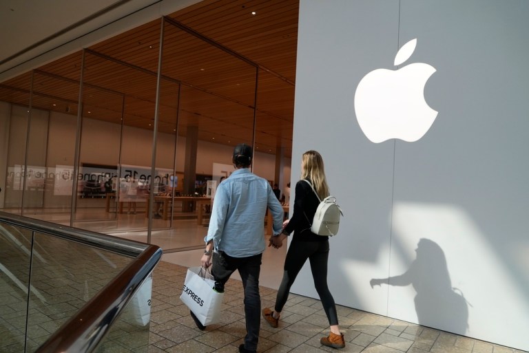 People walk by an Apple store on Oct. 20, 2023, in Denver. Apple is now requiring that U.S. law enforcement agencies obtain a court order for information on its customers' push notifications â the alerts iPhone apps send users that can reveal a lot about their online activity.