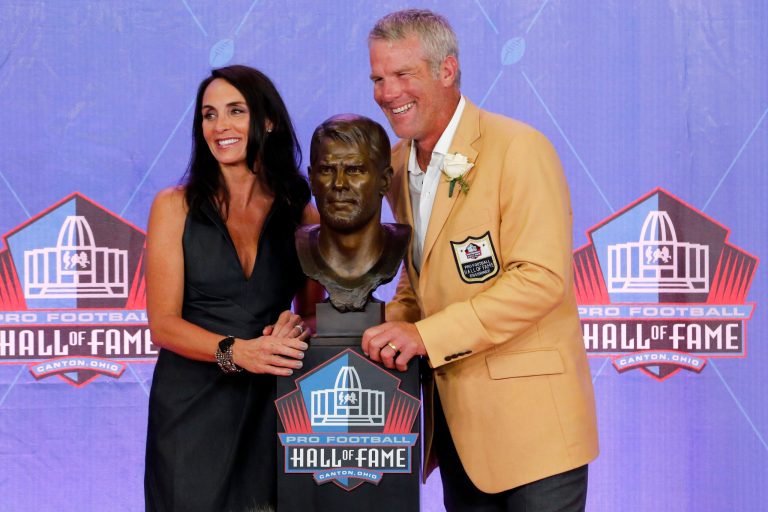 Former NFL player Brett Favre and his wife Deanna pose with a bust of himself during an induction ceremony at the Pro Football Hall of Fame Saturday, Aug. 6, 2016, in Canton, Ohio.