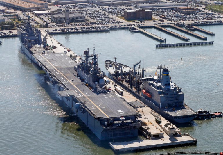 The amphibious assault ship USS Bataan (LHD-5) sits pier side  along with support ships at Naval Station Norfolk in Norfolk, Va.   (AP Photo/Steve Helber)