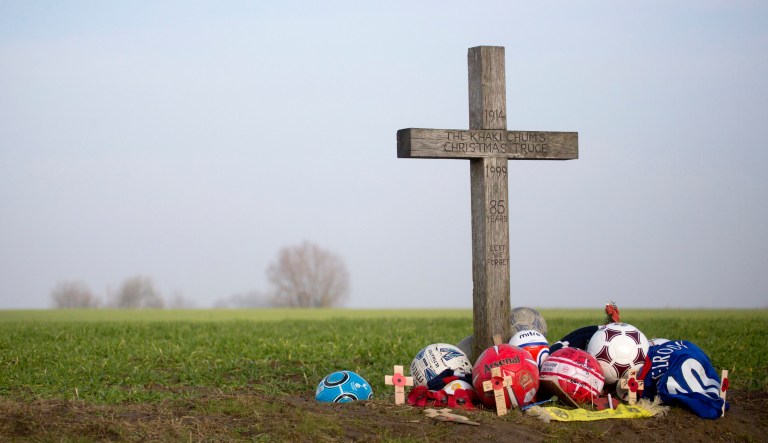 In this Thursday, Dec. 12, 2013 file photo, soccer balls and other mementos are left under the 'Christmas Truce' cross in St. Yvon, Belgium. The cross was erected in 1999 by the Khaki Chums, a group of military enthusiasts to mark the no man's land between British and German troops during WWI.