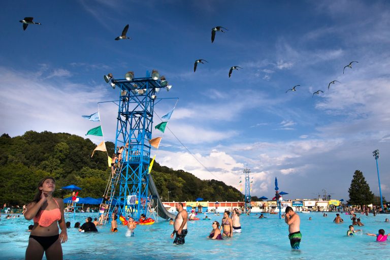 Geese fly south over the Sunlite Pool at Coney Island amusement park, Sunday, Aug. 30, 2015, in Cincinnati. The park first opened in 1886 and will close on Dec. 31, 2023.