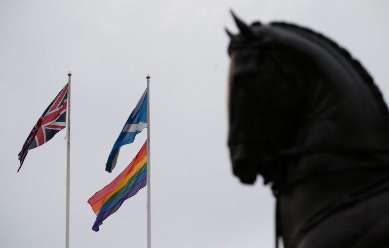 The rainbow flag, bottom right, a symbol of the lesbian, gay, bisexual, and transgender community, flies alongside the British, left, and the Scottish flag over the British government's Scotland Office building, in central London, Friday, March 28, 2014, to mark the start of same-sex weddings in the UK from Saturday March 29, 2014. The British government has ordered rainbow flags to be flown over two prominent government buildings to mark the country's first same-sex weddings, ahead of the law taking effect on Saturday. It marks a profound shift in attitudes in a country that little more than a decade ago had a law on the books banning the 