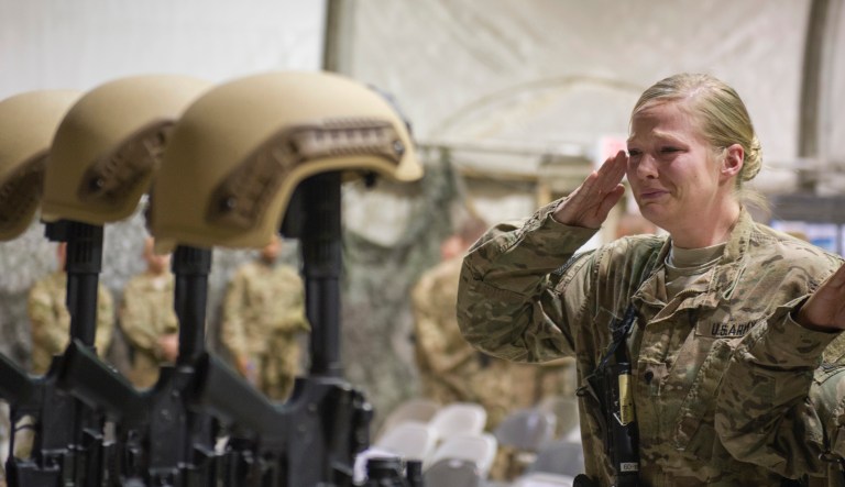 A U.S. service member salutes her fallen comrades during a memorial ceremony for six Airmen killed in a suicide attack, at Bagram Air Field, Afghanistan on Wednesday, Dec. 23, 2015. 