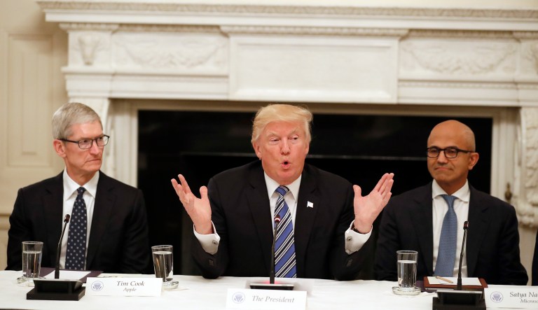 President Donald Trump, center, speaks as he is seated between Tim Cook, Chief Executive Officer of Apple, left, and Satya Nadella, Chief Executive Officer of Microsoft, right, during an American Technology Council roundtable in the State Dinning Room of the White House, Monday, June 19, 2017, in Washington.