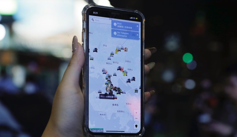 A person's phone shows HKmap.live apps as they join others at a rally to mark Taiwan's National Day, in the Tsim Sha Tsui district in Hong Kong, Thursday, Oct. 10, 2019.  A Hong Kong government official said on Thursday that Apple was responsible for removing a smartphone application which allowed activists to report police movements.