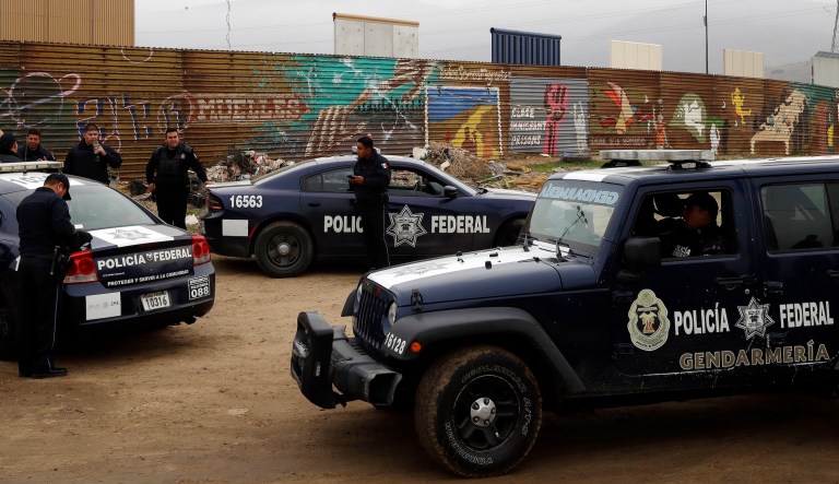Mexican federal police officers stand guard on the Mexico side of the border on Tuesday, March 13, 2018, in Tijuana, Mexico.