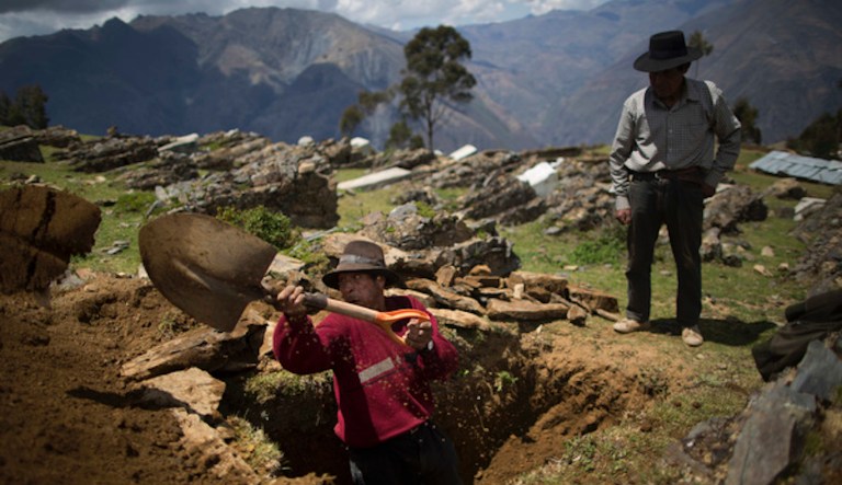 In this Oct. 29, 2014 photo, Dionisio Mulla digs a grave for his brother-in-law Felix Huaman in Huallhua in Peru's Ayahuanco district.