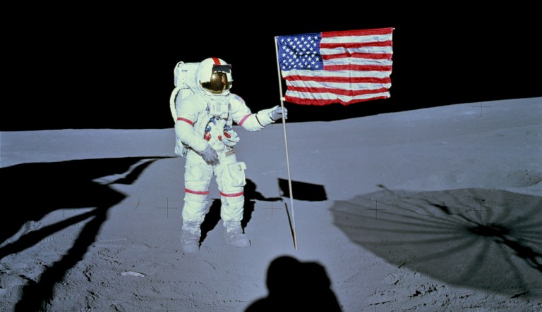Astronaut Alan B. Shepard Jr., commander of the Apollo 14 lunar landing mission, stands by the deployed United States flag on the lunar surface during the early moments of the first extravehicular activity (EVA) of the mission. 