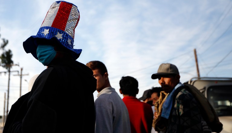 Cristian Mejia, of El Salvador, waits with others in line for food, outside of a shelter for members of the migrant caravan, in Tijuana, Mexico, Tuesday, Nov. 27, 2018.