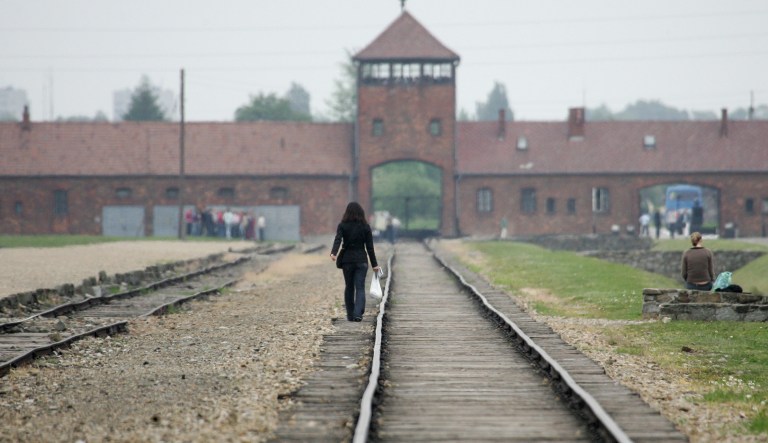 A young visitor walks on the railroad tracks towards the Nazi death camp of Auschwitz-Birkenau, in Poland, Wednesday May 24, 2006.