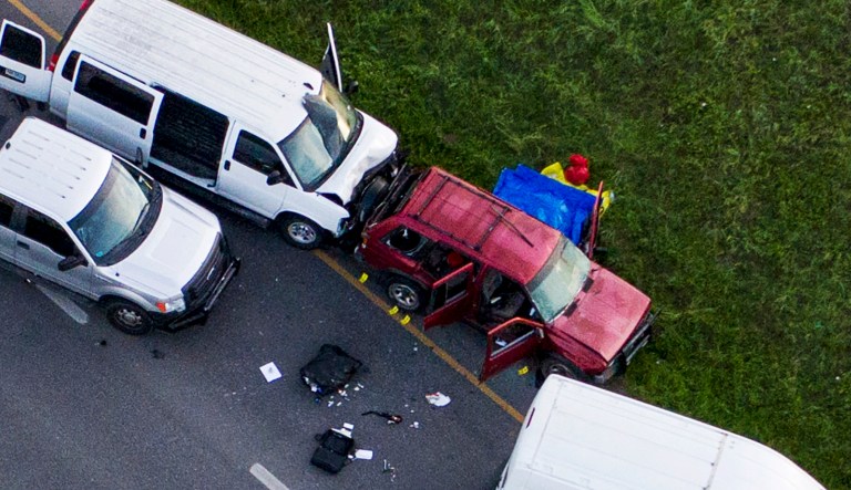 Officials investigate near a vehicle, center, where a suspect in the deadly bombings that terrorized Austin blew himself up as authorities closed in on him, in Round Rock, Texas, Wednesday, March 21, 2018.
