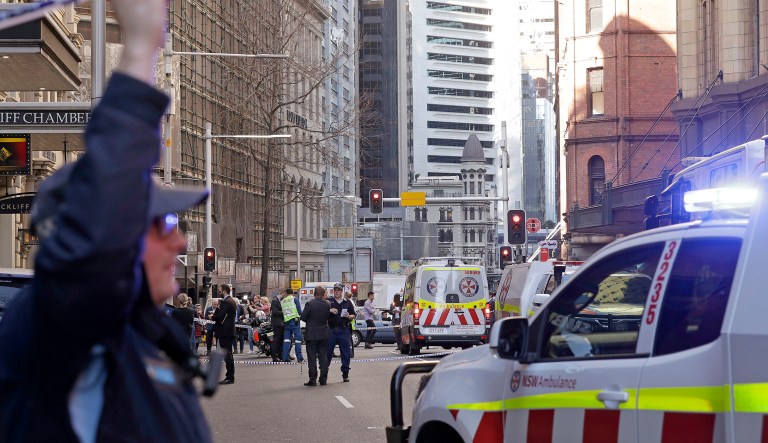 Emergency workers stand at a scene after a man, wielding a long knife, attempted to stab several people in Sydney, Australia, Tuesday, Aug. 13, 2019.