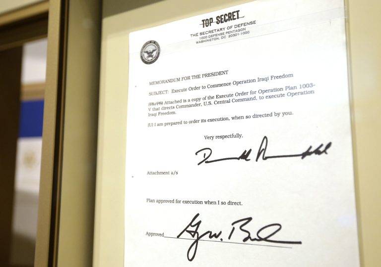 This May 1, 2013 file photo shows the Top Secret executive order commencing operation Iraqi Freedom signed by former President George W. Bush hangs in the Bush Presidential Library and Museum in Dallas. (AP Photo/Tony Gutierrez, File)
