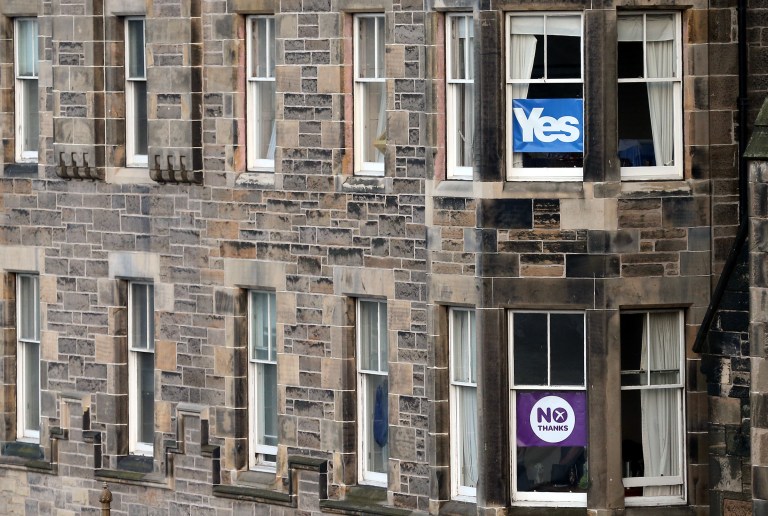 Adjoining apartments display No and Yes signs in their windows in in Edinburgh, Scotland, Tuesday, Sept. 16, 2014. The two sides in Scotland's independence debate are scrambling to convert undecided voters, with just two days to go until a referendum on separation. Anti-independence campaigners are pushing home their message that a 