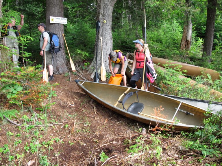 In this photo taken on Tuesday, July 8, 2014, paddlers prepare to launch their canoes at a rugged launch site on Deer Pond in the Essex Chain Lakes tract near Newcomb, N.Y. The tract, which includes more than a dozen small lakes, was purchased by the state in 2012 and opened for canoe camping this summer. (AP Photo/Mary Esch)