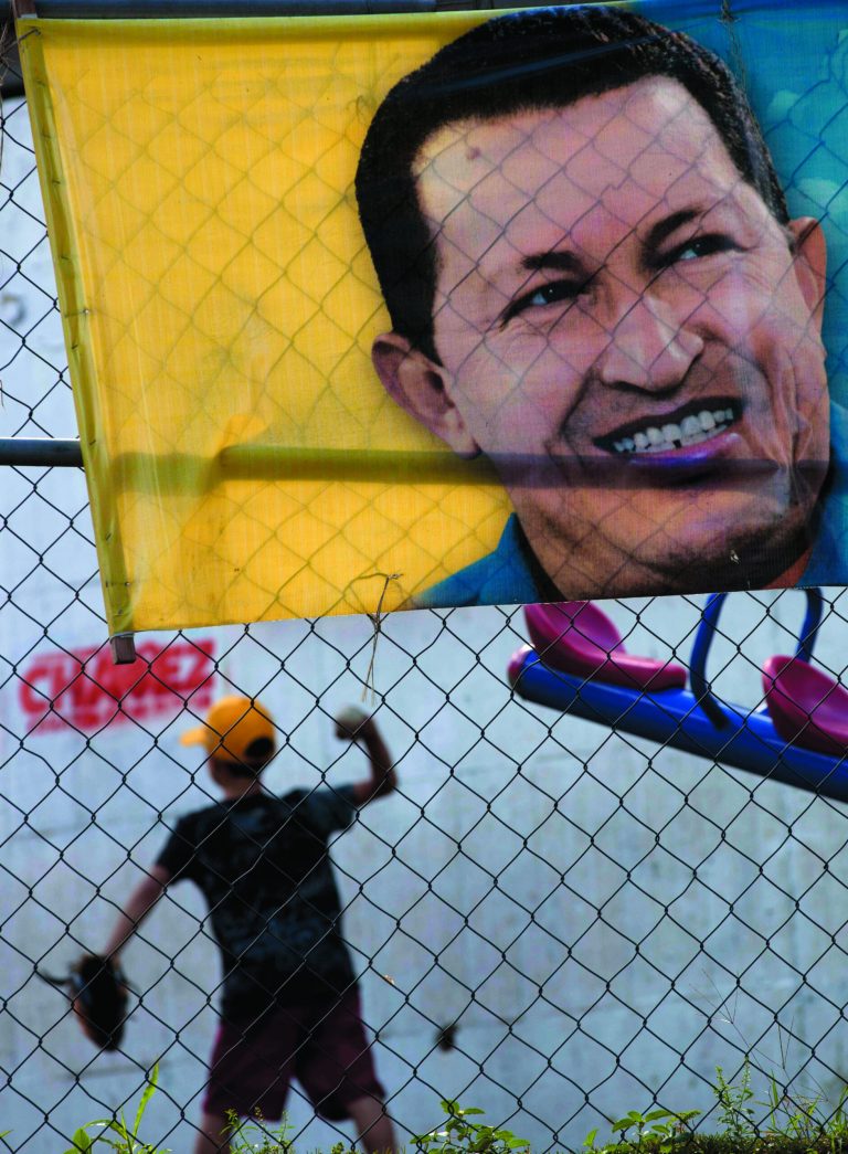 A boy plays behind a poster with an image depicting Venezuela's President Hugo Chavez in Caracas, Venezuela, Thursday, Jan. 3, 2013. The ailing president's health crisis has raised contentious questions ahead of the swearing-in set for Jan. 10, including whether the inauguration could legally be postponed. The ailing president's health crisis has raised contentious questions ahead of the swearing-in set for Jan. 10, including whether the inauguration could legally be postponed. Officials have raised the possibility that Chavez might not be well enough to take the oath of office, without saying what will happen if he can't. The constitution says that if a president or president-elect dies or is declared unable to continue in office, presidential powers should be held temporarily by the president of the National Assembly and that a new presidential vote should be held within 30 days. (AP Photo/Ariana Cubillos)