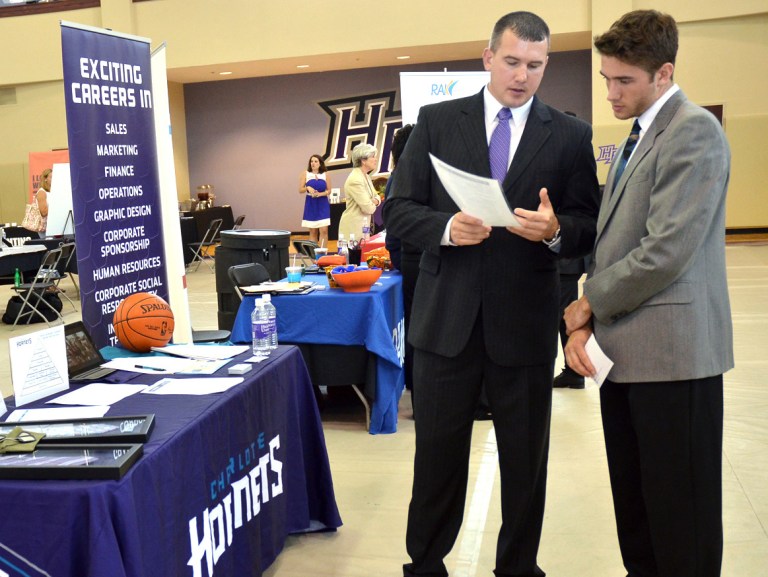 In this Oct. 1, 2014 photo, Matt Fahr, left, sales manager with the Charlotte Hornets, speaks with High Point University freshman, Kule Kubanka, about career opportunities, during a career day at the Slane Student Center in Haigh Point, N.C. The Labor Department releases job openings and labor turnover survey for August on Tuesday, Oct. 7, 2014. (AP Photo/The Enterprise, Laura Greene)