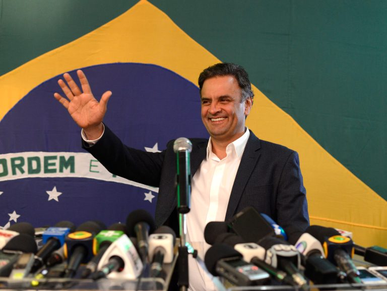Aecio Neves, presidential candidate of the Brazilian Social Democracy Party, PSDB, waves during a press conference in Belo Horizonte, Brazil, Sunday, Oct. 5, 2014. Official results showed Sunday that President Dilma Rousseff will face challenger Aecio Neves in a second-round vote in Brazil's most unpredictable presidential election since the nation's return to democracy nearly three decades ago.(AP Photo/Eugenio Savio)