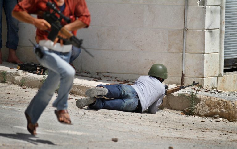   A Free Syrian Army fighter fires his weapon during clashes with Syrian troops near Idlib, Syria, Friday, June 15, 2012. (AP Photo)  