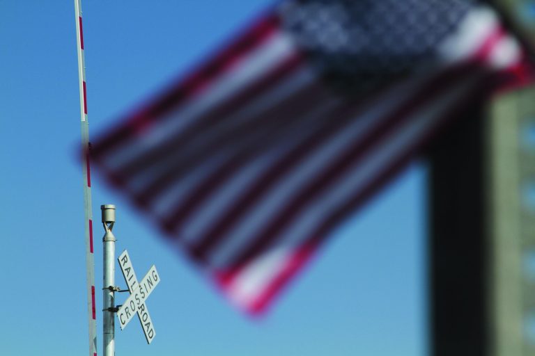 A flag flies at the scene of an accident where four veterans were killed and 16 other people were injured when a train slammed into a parade float carrying the returning heroes to a banquet last Thursday in Midland, Texas on Saturday, Nov. 17, 2012. Federal investigators were trying to determine whether the two-float parade had been given enough warning to clear the tracks. (AP Photo/Juan Carlos Llorca)