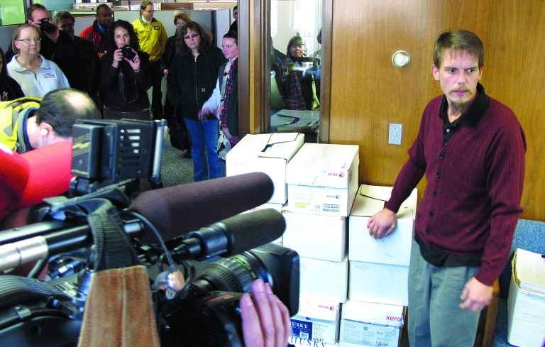 Chris McManus, the sponsor of Initiative 522, speaks to reporters as he stands next to boxes of signed petitions he dropped off at the state's elections division office on Thursday, Jan. 3, 2012, in Olympia, Wash. The measure would require the labeling of any food and seeds sold in Washington that were produced through genetic engineering. (AP Photo/Rachel La Corte)