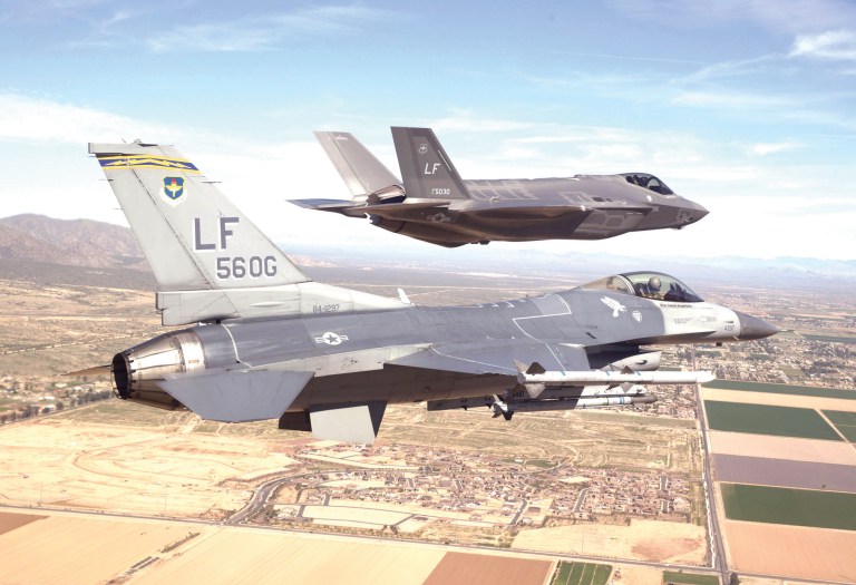Justin Robinson flies the 56th Operations Group flagship F-16 Fighting Falcon as he escorts the first F-35 Lightning II to Luke Air Force Base, AZ. Mar. 10, 2014.Â (Rex Features via AP Images)