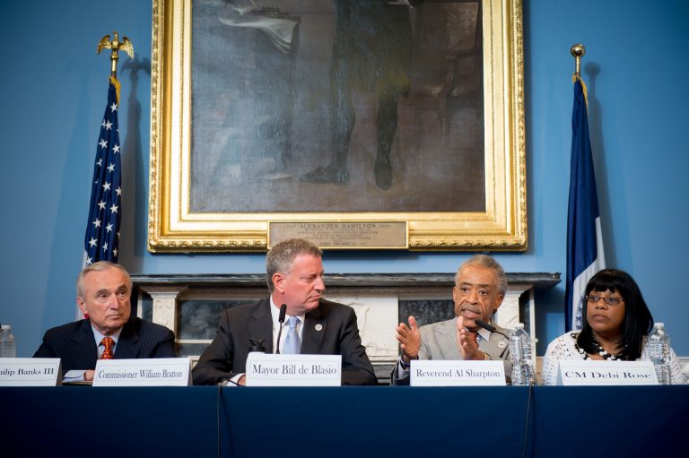 In this July 31, 2014, photo provided by the New York City Mayoral Photography Office, The Rev. Al Sharpton, second right, speaks to the audience in New York during a roundtable discussion convened by New York Mayor Bill de Blasio, center left, to ease tensions over the July 17, police involved death of Eric Garner. Garner, who was asthmatic, was being arrested on suspicion of selling loose cigarettes and died soon after being placed in the apparent choke hold by a police officer. From left are New York City Police Commissioner William Bratton; de Blasio, Sharpton and New York City Council member Debi Rose.  (AP Photo/New York City Mayoral Photography Office, Bob Bennett)