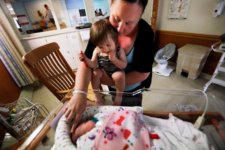Amanda Fielding and her daughter. Briella Debonise, 20 months, take a closer look at Braylin Debonise, 9 days old. Amanda, who has been a recovering heroin addict, has seen both of her daughters born with an addiction to methadone. Braylin is given a combination of morphine and Phenobarbital with her formula daily, while Briella has already been weaned off her addiction. (Peter Pereira/Standard-Times via AP)