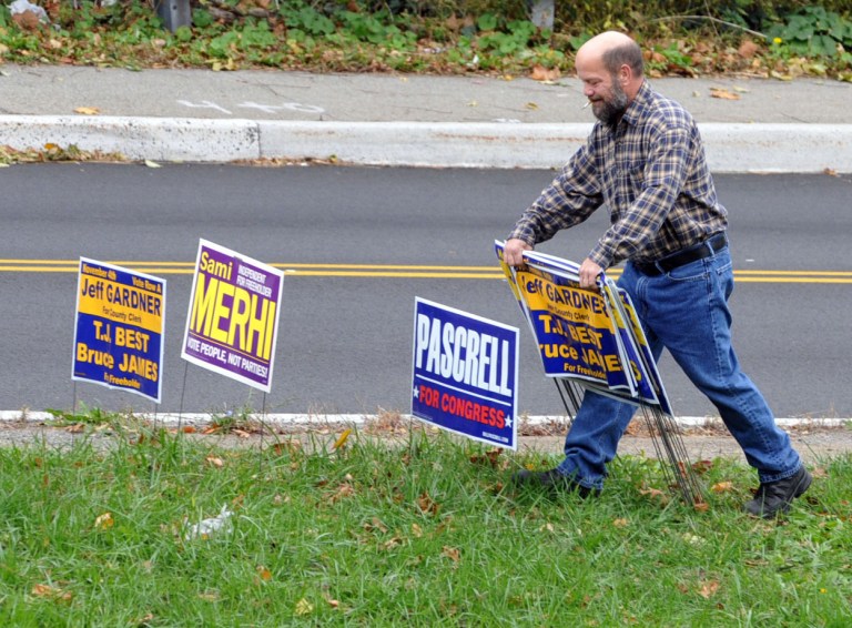 Woodland Park building department worker takes down hundreds of election signs in Woodland Park, N.J. on Wednesday, Nov. 5, 2014. (AP Photo/The Record of Bergen County, Don Smith)