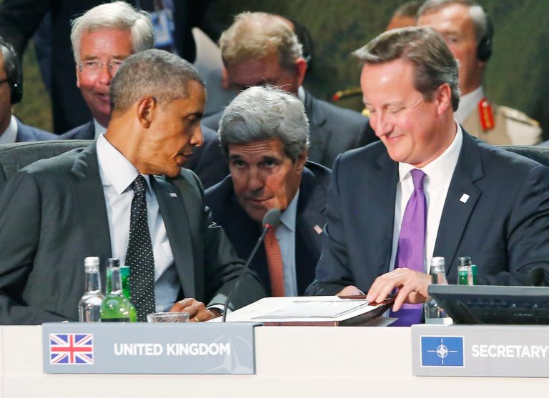 Secretary of State John Kerry, center, talks with President Barack Obama as British Prime Minister David Cameron, right, finishes speaking at a meeting of NATO leaders regarding Afghanistan at the NATO summit at Celtic Manor in Newport, Wales, Thursday, Sept. 4, 2014. (AP Photo/Charles Dharapak)
