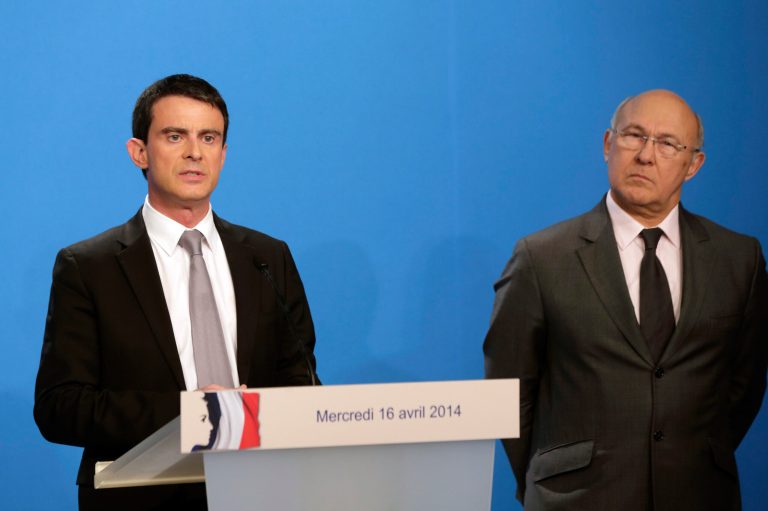 French Prime Minister Manuel Valls delivers a statement while Finance minister Michel Sapin, right, after the weekly cabinet meeting at the Elysee Palace in Paris, Wednesday, April 16, 2014.  Valls provided details of the government's plan to reduce public spending by 50 billion euros ($ 69 billion) and reiterated that France would honor its European commitments on deficit reduction.  (AP Photo/Philippe Wojazer, Pool)
