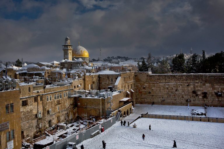 File - In this Dec. 13, 2013 file photo, the Western Wall, right, and the gilded Dome of the Rock, among the holiest sites for Jews and Muslims, are covered in snow. Israeli police stormed a sensitive holy site in Jerusalem on Wednesday, April 16, 2014, firing tear gas to disperse a protest by Palestinian Muslim worshippers, officials said. Police spokesman Micky Rosenfeld said the crowd hurled stones and firecrackers from atop the compound known to Jews as the Temple Mount, the holiest site in Judaism. (AP Photo/Dusan Vranic, File)