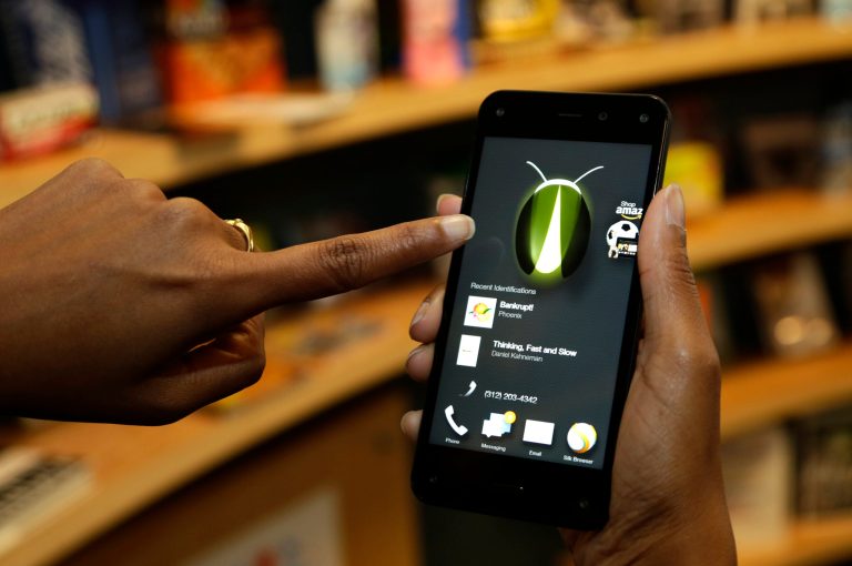 FILE - In this June 18, 2014 file photo, the new Amazon Fire Phone's Firefly feature, which lets the user take a photo of objects, numbers, artwork or books and have the phone recognize the item, is demonstrated in Seattle. Firefly also can recognize songs, TV shows, and movies. (AP Photo/Ted S. Warren, File)