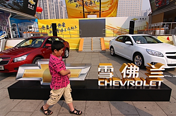 A young Chinese boy walks past Chevrolet cars of GM (General Motors) during a show in Xiangyang city, central Chinas Hubei province, 2 October 2012. (AP Photo)