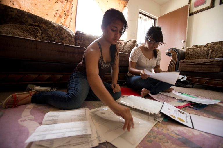 Itzel Guillen, left, sorts out some of the documents she needs to apply for a work permit along with Lucero Maganda, right, at her home in San Diego, Ca. (AP/Gregory Bull)