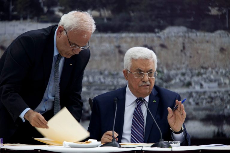 FILE - In this Tuesday April 1, 2014 photo, Palestinian President Mahmoud Abbas, right, jointed by Palestinian chief peace negotiator Saeb Erekat, signs an application to the U.N. agencies in the West Bank city of Ramallah. The Palestinians are not walking away from U.S.-led efforts to reach a peace deal with Israel, a top Palestinian official said Wednesday, a day after their renewed bid for international recognition of a 