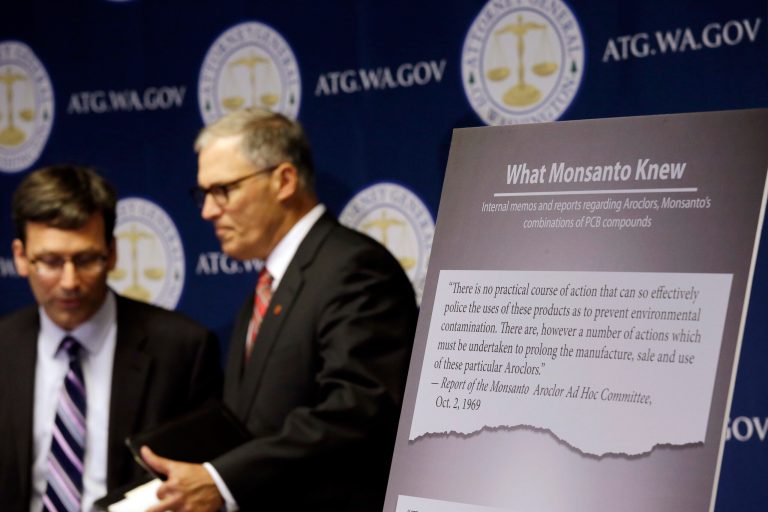 Washington Attorney General Bob Ferguson, left, introduces Gov. Jay Inslee at a news conference where Ferguson announced a lawsuit against agrochemical giant Monsanto over pollution from PCBs on Dec. 8 in Seattle. The chemicals, polychlorinated biphenyls, were used in many industrial and commercial applications, including in paint, coolants, sealants and hydraulic fluids. PCB contamination impairs rivers, lakes and bays around the country. (AP Photo/Elaine Thompson)