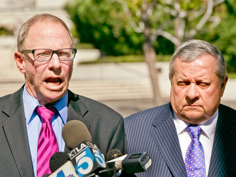 Attorneys Steven Lerman, left, and Federico Castelan take questions from the media, after filing a federal civil rights lawsuit against the Los Angeles Police Department, and the two officers who shot Ezell Ford, a black man killed last month by the police officers, outside the U.S. District Court in Los Angeles Wednesday, Sept. 17, 2014. The 25-year-old was unarmed when police confronted him Aug. 11 on a street near his home. Officers said they shot him when he tried to grab a gun during a struggle.  (AP Photo/Damian Dovarganes)