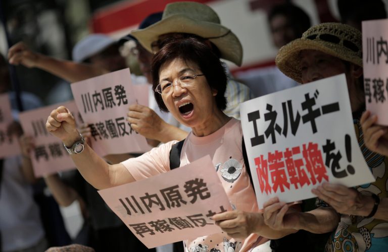 Protesters shout slogans against a Japanese nuclear plant which won preliminary approval Wednesday for meeting stringent post-Fukushima safety requirements, near the Diet builidng in Tokyo, Wednesday, July 16, 2014. The Nuclear Regulation Authority gave preliminary approval Wednesday to a report that concludes that two reactors at Sendai Nuclear Power Station have complied with the new regulations and are capable of avoiding disasters such as the Fukushima Dai-ichi meltdowns, even if the plant faces equally harsh conditions. The placard at right reads: 