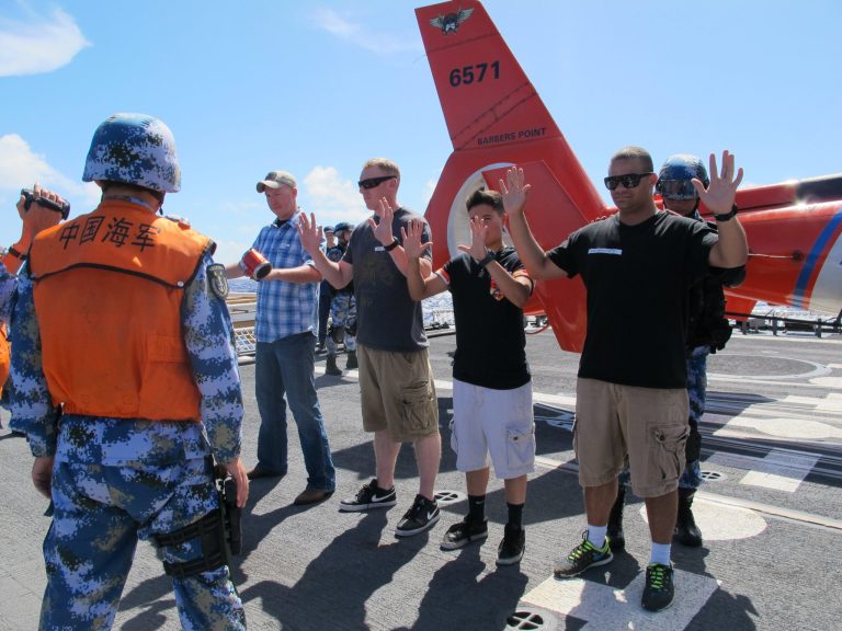 People's Liberation Army sailors pat down U.S. Coast Guardsmen playing the role of merchant mariners aboard the Coast Guard cutter Waesche off Hawaii on Wednesday, July 16, 2014. Chinese sailors boarded the Coast Guard cutter Waesche for a drill checking cargo as part of Rim of the Pacific exercises the U.S. is hosting in Hawaii waters this month. (AP Photo/Audrey McAvoy)