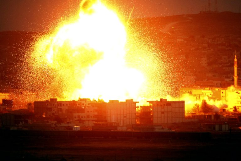 An explosion rocks the Syrian city of Kobani during an airstrike by the US-led coalition during fighting between Syrian Kurds and the militants of Islamic State group, as seen from the outskirts of Suruc, on the Turkey-Syria border, October 18, 2014. (Photo by Gokhan Sahin/Getty Images)