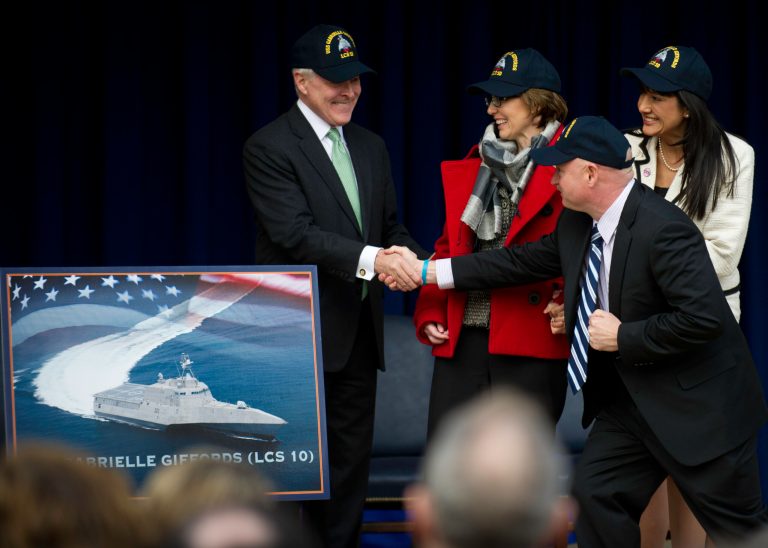 Navy Secretary Ray Mabus shakes hands with retired Navy Capt. Mark Kelly, husband of Gabrielle Giffords, center, at the Pentagon in 2012. Mabus had just announced that the Navy's 10th littoral combat ship will be named after Giffords. (Chief Mass Communication Specialist Sam Shavers, U.S. Navy)