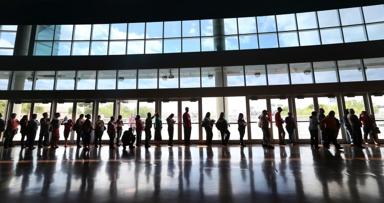People line up to enroll for health insurance at the Alamodome in San Antonio, Texas on Monday, March 31, 2014.  The deadline is just hours away to sign up for insurance in the first enrollment period under President Barack Obama's signature health care law.  (AP Photo/San Antonio Express-News, Jerry Lara)  RUMBO DE SAN ANTONIO OUT; NO SALES