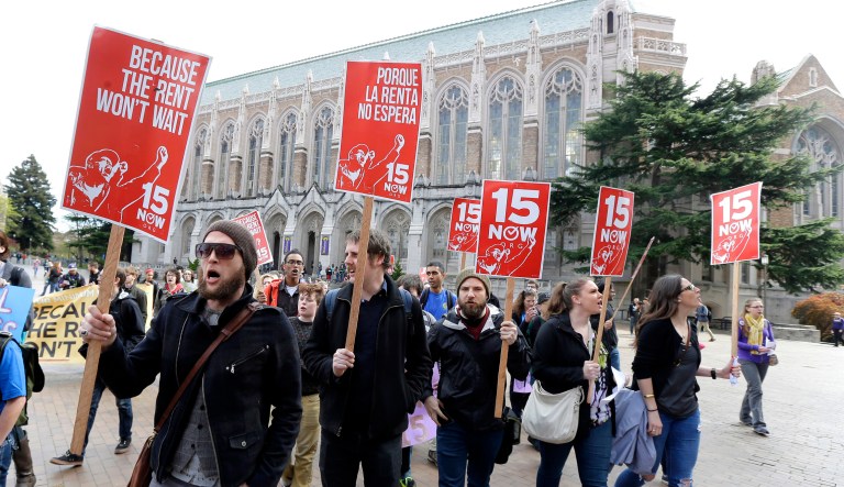 In this April 1, 2015, file photo, students and other supporters protest on the University of Washington campus in Seattle, in support of raising the minimum wage for campus workers to $15 an hour. Seattle's $15-an-hour minimum wage law has cost the city jobs, according to a study released Monday, June 26, 2017, that contradicted another new study published last week. (AP Photo/Ted S. Warren, File)