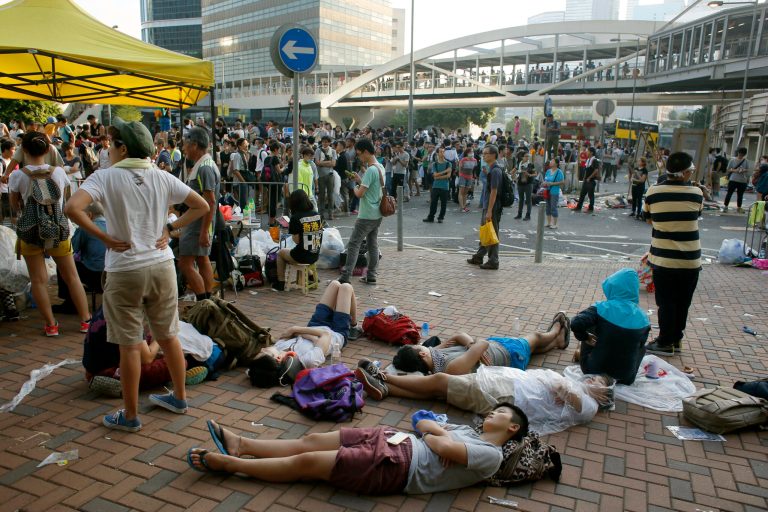 Despite a night of clashes with riot police, student protesters continue to occupy the streets surrounding the government headquarters in Hong Kong, early Monday, Sept. 29, 2014. Pro-democracy demonstrators defied onslaughts of tear gas and appeals from Hong Kong's top leader to go home, as the protests over Beijing's decision to limit political reforms expanded across the city early Monday. (AP Photo/Wally Santana)