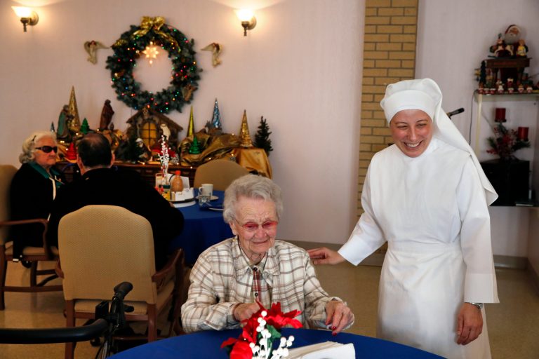 Sister Mary Grace visits with a resident at the Mullen Home for the Aged, run by Little Sisters of the Poor, in Denver, Colo., on Jan. 2. (AP Photo/Brennan Linsley)