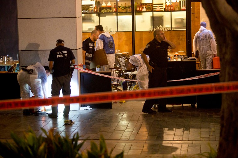 Israeli police officers examine the scene of a shooting attack in Tel Aviv, Israel. (AP Photo/Sebastian Scheiner)