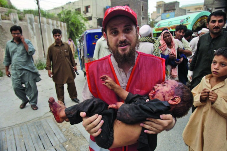 A Pakistani rescue worker carries a child, who was injured in an explosion in a Sunni shrine, to a hospital in Peshawar, Pakistan, Thursday, June 21, 2012. A Pakistani police officer said that two children were killed by the explosion at the shrine as dozens of people gathered there.(AP Photo/Mohammad Sajjad)