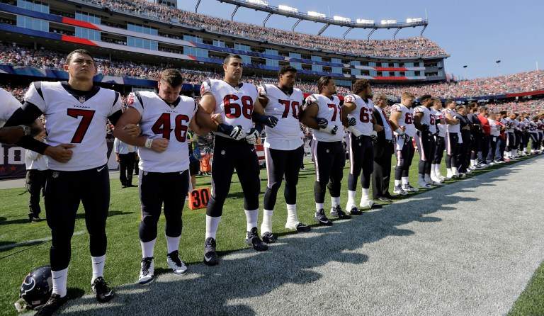 Members of the Houston Texans team stand with arms locked during the national anthem before an NFL football game against the New England Patriots, Sunday, Sept. 24, 2017, in Foxborough, Mass. (AP Photo/Steven Senne)