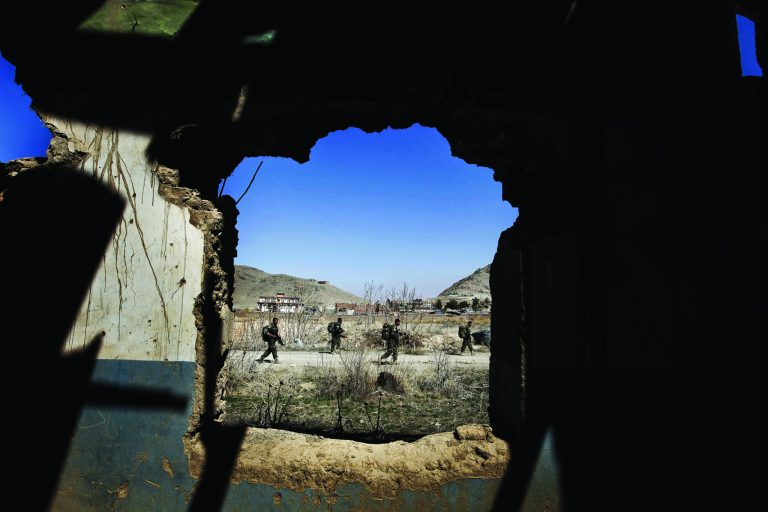 FILE - In this March 22, 2011, file photo, Afghan National Special Force soldiers patrol during a training session, seen through a destroyed building at Camp Morehead on the outskirts of Kabul, Afghanistan. U.S. soldiers serving in one of southern Afghanistan's most violent areas say they are successfully training the Afghans to secure their country and their progress so far will play a large role in determining how many more American troops President Barack Obama sends home next year. (AP Photo/Dar Yasin, File)